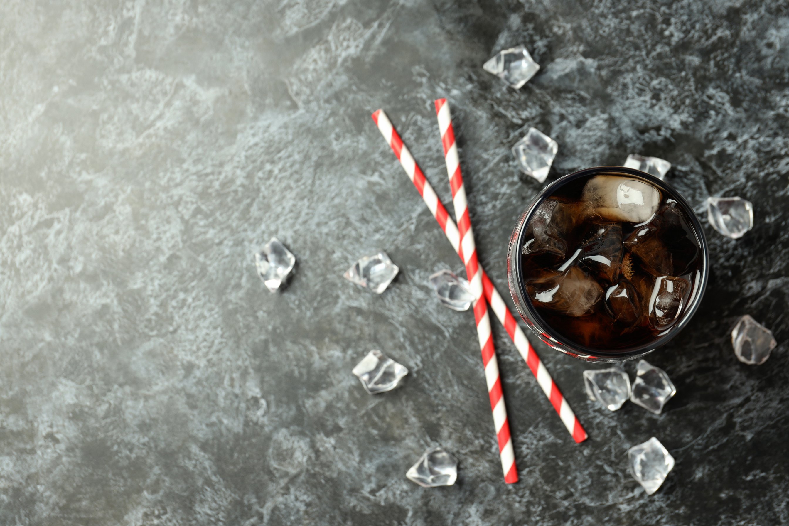 Glass of Cola, Ice and Straws on Black Smokey Background